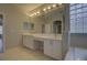 Bathroom featuring dual sinks, vanity seating area, a decorative glass block window, and modern lighting at 19334 Autumn Woods Ave, Tampa, FL 33647
