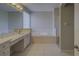 Bright bathroom featuring a soaking tub, glass block window, and white vanity with countertop space at 19334 Autumn Woods Ave, Tampa, FL 33647