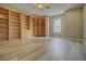 Large bonus room features extensive built-in shelving and wood-style floors, perfect for a home office or library at 19334 Autumn Woods Ave, Tampa, FL 33647