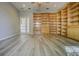 Large bonus room features extensive built-in shelving and wood-style floors, perfect for a home office or library at 19334 Autumn Woods Ave, Tampa, FL 33647