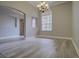 Bright dining room boasts wood-style floors, elegant chandelier, large arched window, and neutral wall paint at 19334 Autumn Woods Ave, Tampa, FL 33647