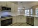 Bright kitchen featuring white cabinetry, stainless steel appliances, and hardwood floors at 19334 Autumn Woods Ave, Tampa, FL 33647