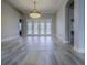 Bright living room featuring hardwood floors, neutral walls, and a modern light fixture at 19334 Autumn Woods Ave, Tampa, FL 33647