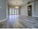 Bright living room featuring hardwood floors, neutral walls, and a modern light fixture at 19334 Autumn Woods Ave, Tampa, FL 33647