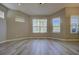 Bright living room with wood-style floors features many windows for natural light and neutral colored walls at 19334 Autumn Woods Ave, Tampa, FL 33647
