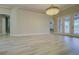 Bright living room featuring hardwood floors, neutral walls, and a modern light fixture at 19334 Autumn Woods Ave, Tampa, FL 33647