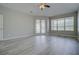 Bright living room featuring neutral walls, flooring, and large windows with access to the outdoors through French doors at 19334 Autumn Woods Ave, Tampa, FL 33647
