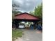 Covered carport with a car and various items stored underneath at 33255 State Road 70 E, Myakka City, FL 34251