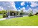 Mobile home with covered patio and lush green lawn at 6048 Ridgeway Dr, Zephyrhills, FL 33542