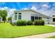 White mobile home with well-maintained landscaping at 6048 Ridgeway Dr, Zephyrhills, FL 33542