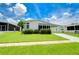 White mobile home with carport and lush landscaping at 6048 Ridgeway Dr, Zephyrhills, FL 33542