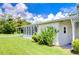 Mobile home side view with covered patio and lush lawn at 6048 Ridgeway Dr, Zephyrhills, FL 33542