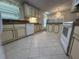 Bright kitchen featuring an island, ample cabinetry, and tile flooring at 6048 Ridgeway Dr, Zephyrhills, FL 33542