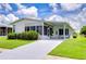 Single-wide mobile home with carport and well-manicured lawn at 6048 Ridgeway Dr, Zephyrhills, FL 33542