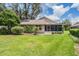 Expansive backyard with a screen enclosed patio, beautiful grass, and mature landscaping at 6536 Northlake Dr, Zephyrhills, FL 33542