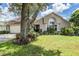 Exterior shot featuring the lawn, shade trees, and front of the house at 6536 Northlake Dr, Zephyrhills, FL 33542