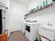 Bright laundry room with washer, dryer, utility sink, and shelving at 15503 Corona Del Mar Dr, Wimauma, FL 33598