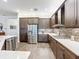 Modern kitchen with stainless steel appliances and dark wood cabinets at 15503 Corona Del Mar Dr, Wimauma, FL 33598