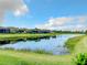 Scenic view of a tranquil lake, lush greenery, and upscale homes at 15503 Corona Del Mar Dr, Wimauma, FL 33598
