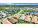 Aerial view of a residential neighborhood with tennis courts and a lake at 15503 Corona Del Mar Dr, Wimauma, FL 33598