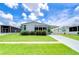 Single-wide manufactured home with carport, landscaping, and paved driveway at 6048 Ridgeway Dr, Zephyrhills, FL 33542