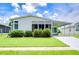 Single-wide manufactured home with carport, landscaping, and paved driveway at 6048 Ridgeway Dr, Zephyrhills, FL 33542
