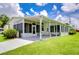 Single-wide manufactured home with covered patio and lush landscaping at 6048 Ridgeway Dr, Zephyrhills, FL 33542