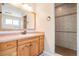 Bathroom with wood vanity, tiled shower, and large mirror at 6536 Northlake Dr, Zephyrhills, FL 33542