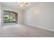 Bright bedroom featuring carpet flooring and sliding glass doors to a screened patio at 6536 Northlake Dr, Zephyrhills, FL 33542