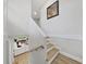 Modern staircase with light wood treads and white risers, overlooking a living room at 6902 E 29Th Ave, Tampa, FL 33619