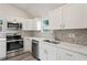 Modern kitchen with white cabinets, quartz countertops, and stainless steel appliances at 2395 19Th St, Sarasota, FL 34234