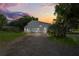 Gray barn-style building with three garage doors, set against a vibrant sunset at 2395 19Th St, Sarasota, FL 34234