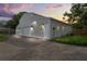 Modern gray barn-style building with three garage doors and a driveway at dusk at 2395 19Th St, Sarasota, FL 34234