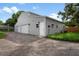Modern gray barn-style building with three garage doors and a driveway at 2395 19Th St, Sarasota, FL 34234