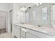 Bright bathroom with double vanity, quartz countertops, modern fixtures, and a large mirror at 1268 Kazaz Ct, Zephyrhills, FL 33540