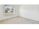 This bedroom features a light tile floor and natural light from the window at 1268 Kazaz Ct, Zephyrhills, FL 33540