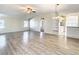 Spacious living room with light wood laminate flooring and kitchen view at 34051 Brown Byu, Wesley Chapel, FL 33543