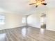 Spacious living room with light wood laminate flooring and bedroom view at 34051 Brown Byu, Wesley Chapel, FL 33543