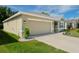 Tan house with a two-car garage and landscaped yard at 18212 Hunters Meadow Walk, Land O Lakes, FL 34638