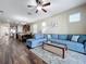 Open living room with sectional sofa, coffee table, and view of kitchen at 32527 Harmony Oaks Dr, Wesley Chapel, FL 33545