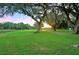 Expansive green lawn with mature oak trees and a scenic walking path at 37222 Cora Ave, Zephyrhills, FL 33542