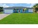 Single-story home with light blue exterior and two-car garage at 16443 Strauss Ave, Port Charlotte, FL 33954