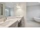 A modern bathroom features double sinks, a soaking tub, and stylish fixtures at 157 Hidden Estates Ct, Brandon, FL 33511