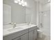 Bright bathroom featuring a double vanity with gray cabinets, modern faucets, and a tiled shower/tub combo at 157 Hidden Estates Ct, Brandon, FL 33511