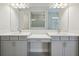 Bright bathroom features double sinks with gray cabinets and a large mirror at 157 Hidden Estates Ct, Brandon, FL 33511