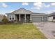 Charming single story home featuring a landscaped lawn, grey exterior paint, and a three car garage at 157 Hidden Estates Ct, Brandon, FL 33511