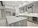 A modern kitchen features a large island, stainless steel appliances, and gray cabinets at 157 Hidden Estates Ct, Brandon, FL 33511