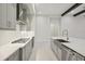 Modern kitchen featuring grey cabinetry, stainless steel appliances, quartz countertops, and a gas range at 157 Hidden Estates Ct, Brandon, FL 33511