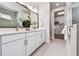 Bright bathroom features double vanity, large mirror, and walk-in closet for ample storage space at 652 Allora Ave, Nokomis, FL 34275