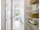 Bright hallway with shelving leads to bathroom and bedroom, offering ample storage at 652 Allora Ave, Nokomis, FL 34275
